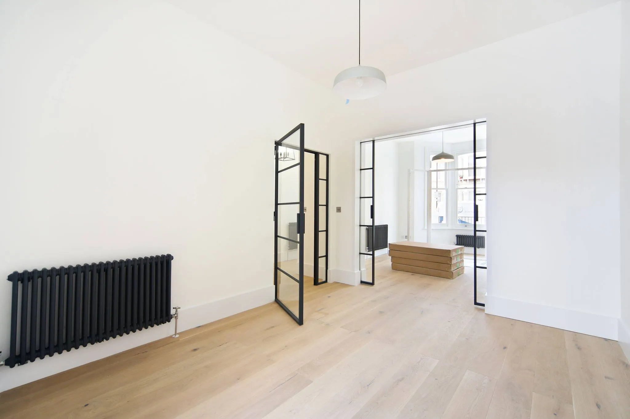 a white room with a radiator and a wooden floor