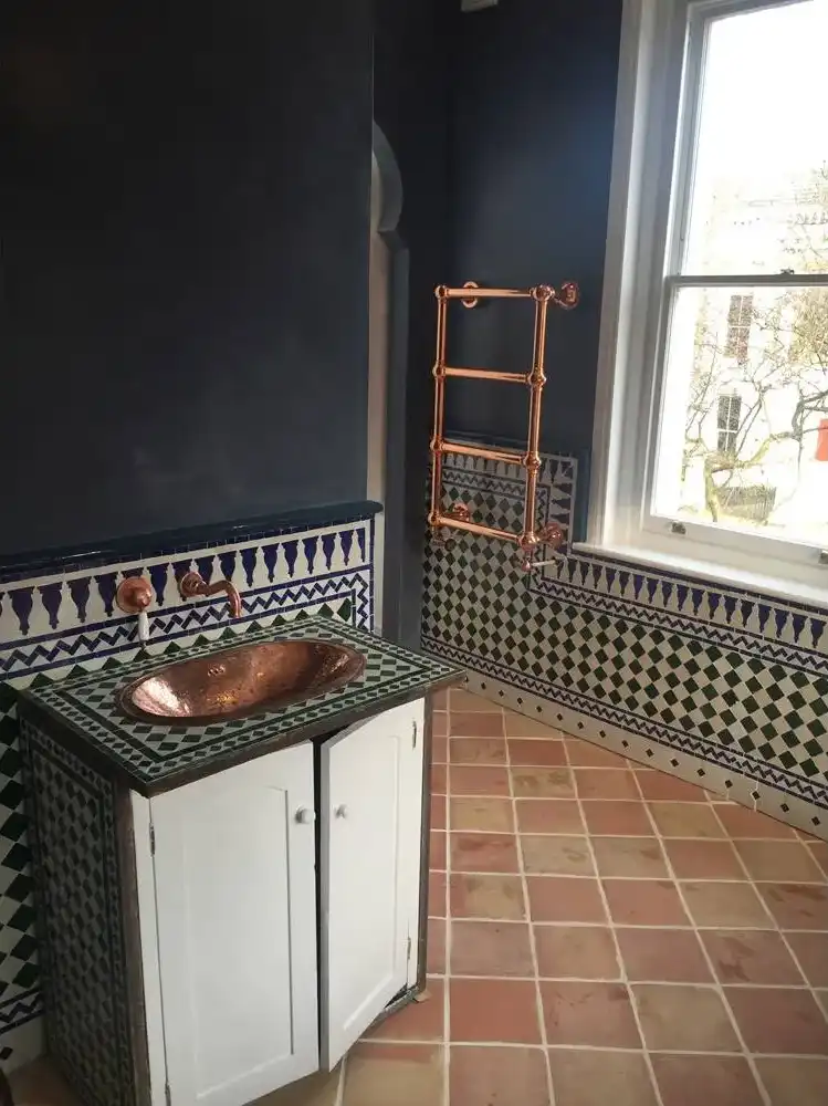 a bathroom with a sink and tiled walls