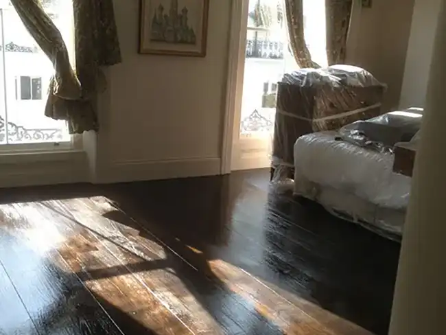 a room with a bed and a wooden floor
